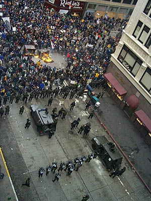 Police in Seattle seal off streets as overturned bins burn.